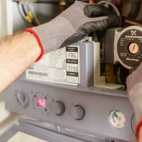 Techniker bei der Wartung einer Heizungsanlage im Haus